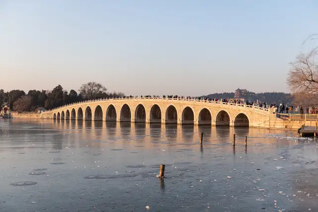 The Seventeen-Arch Bridge crosses frozen Kunming Lake at the Summer Palace in low winter sunlight.